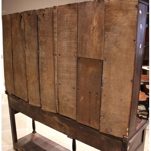 800 - An 18th century oak dresser, the rack with a moulded cornice over a plain frieze applied with iron g... 