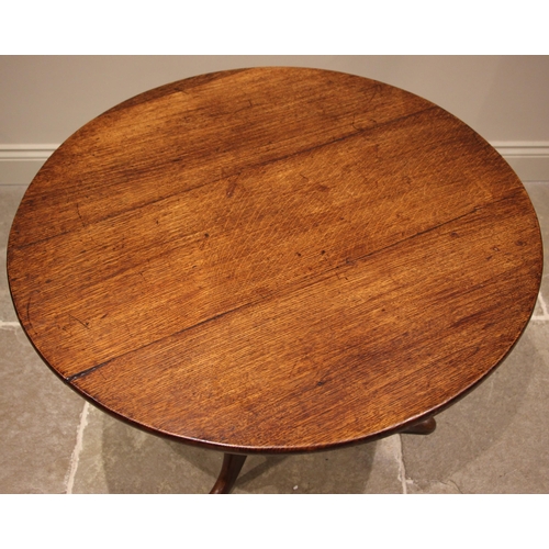 809 - A George III oak tripod table, the circular tilt top upon a turned and tapering column extending to ... 