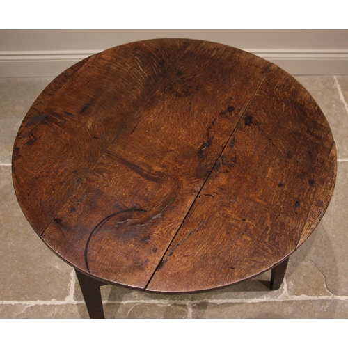 816 - A 19th century oak cricket table, the circular plank top upon three chamfered supports, united by a ... 