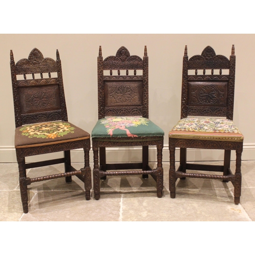 836 - A trio of carved oak hall/side chairs in the 17th century style, late 19th century, each with spire ... 