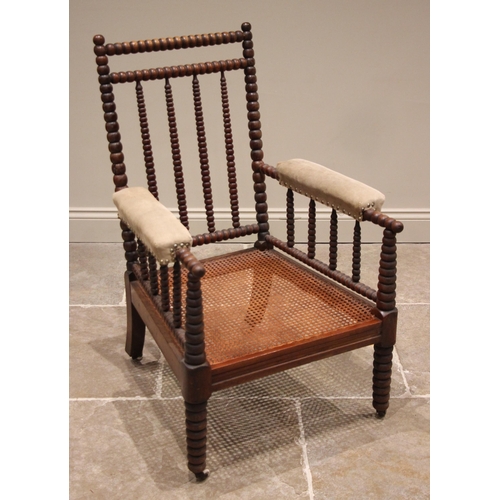 840 - A mahogany bobbin turned armchair, mid to late 19th century, the bobbin frame enclosing a cane work ... 