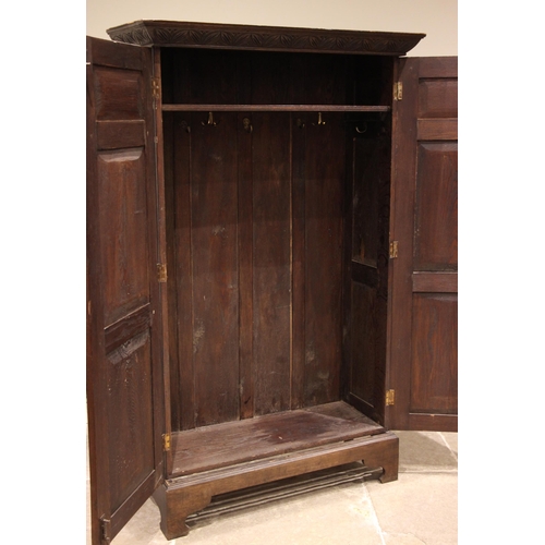 841 - A 17th century revival oak hall cupboard, late 19th/early 20th century, the carved cornice over a nu... 