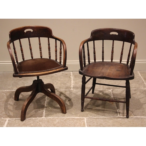 886 - An oak revolving office desk chair, early 20th century, the spindle back over a studded pad bowfront... 