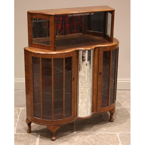 900 - A 1940's walnut cocktail cabinet, the upper section with glass sliding doors and mirrored back plate... 