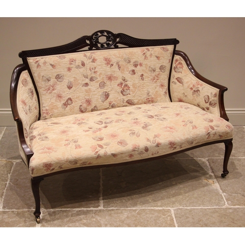 901 - An Edwardian mahogany framed sofa, re-upholstered in floral fabric, the carved oval open work crest ... 