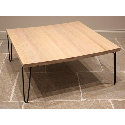 904 - A contemporary light oak slab top coffee/centre table, early 21st century, the square top upon paint... 