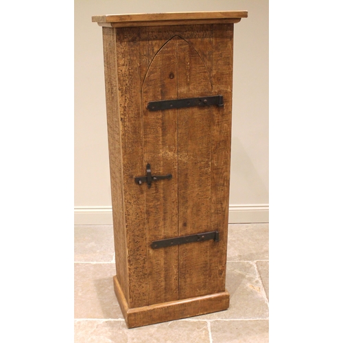 914 - A rustic pine hall cabinet, late 20th century, the lancet shaped door applied with iron strap hinges... 