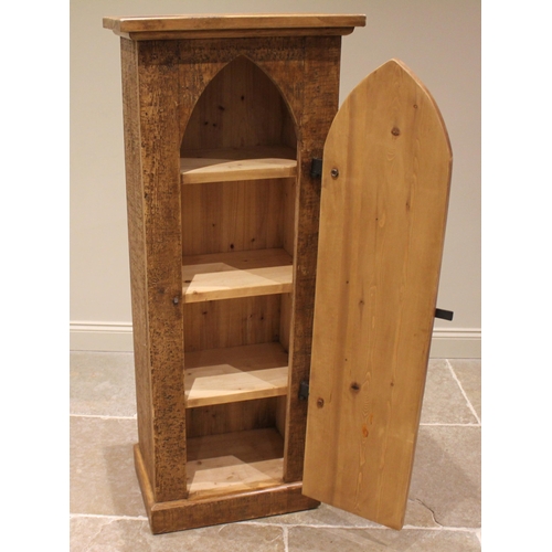 914 - A rustic pine hall cabinet, late 20th century, the lancet shaped door applied with iron strap hinges... 