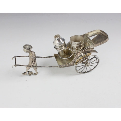 95 - A silver plated cruet set, modelled as a man and cart, with triple cruet set, 23cm long, with a nove... 