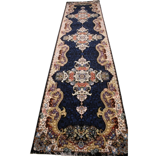 717 - A fine woven Iranian runner, multi coloured with three bespoke medallions upon a navy blue ground, e... 