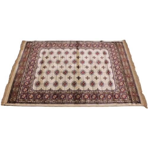 719 - An ivory ground Kashmir traditional Bokhara rug, in red, blue and ivory colourways, the central fiel... 