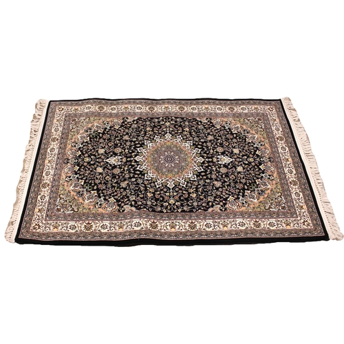 721 - A black ground fine woven Iranian rug, the all over floral design with a central lozenge medallion, ... 