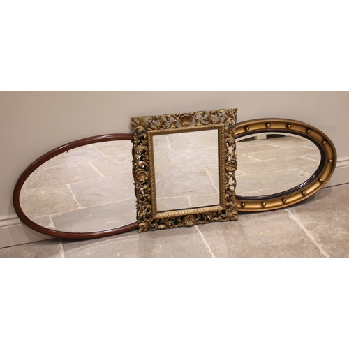 710 - A giltwood Florentine wall mirror, late 19th century, the scrolling open work foliate frame punctuat... 