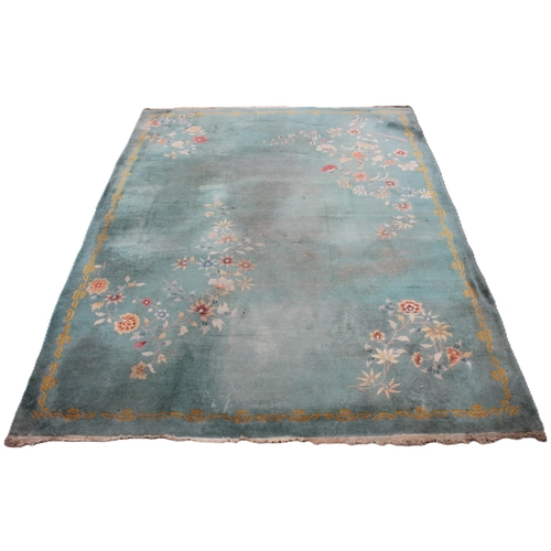 734 - A large Chinese wool carpet, early 20th century, with floral motifs against a duck egg blue ground, ... 