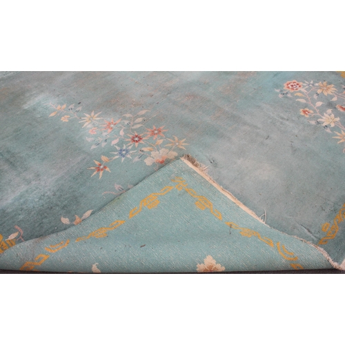 734 - A large Chinese wool carpet, early 20th century, with floral motifs against a duck egg blue ground, ... 