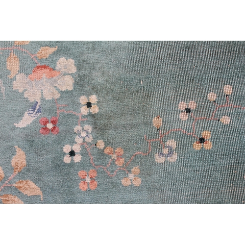 734 - A large Chinese wool carpet, early 20th century, with floral motifs against a duck egg blue ground, ... 