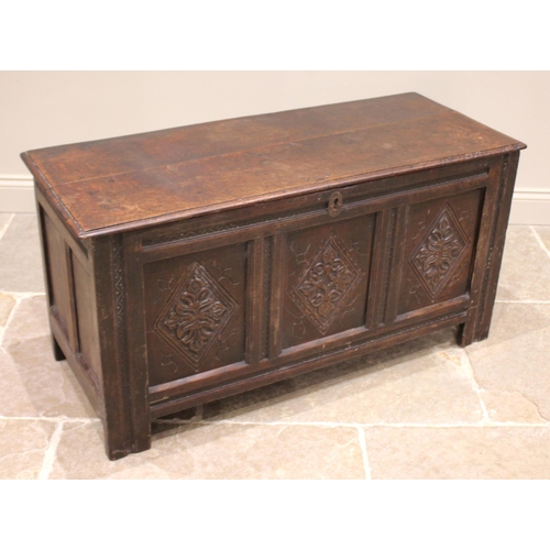 794 - An 18th century oak coffer, the moulded two plank top with carved serrated banding, opening to a fit... 