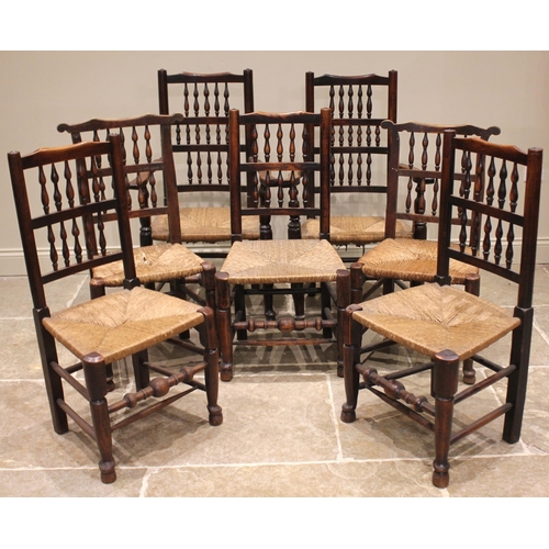 803 - A harlequin set of seven ash spindle back and rush seated chairs, early 19th century, each with two ... 