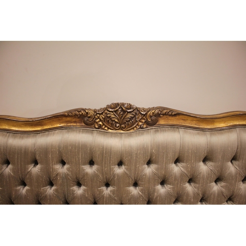 863 - A French Louis XV style giltwood bed, late 20th century, the padded button back head board within a ... 