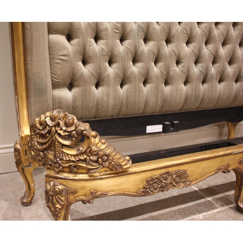 863 - A French Louis XV style giltwood bed, late 20th century, the padded button back head board within a ... 