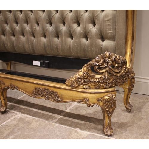 863 - A French Louis XV style giltwood bed, late 20th century, the padded button back head board within a ... 