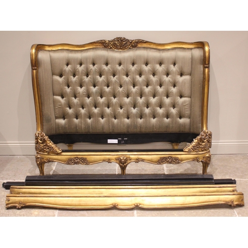 863 - A French Louis XV style giltwood bed, late 20th century, the padded button back head board within a ... 