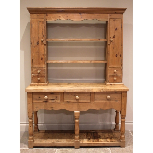 884 - A Victorian style pine dresser, late 20th century, the plate rack with a moulded cornice over a shap... 