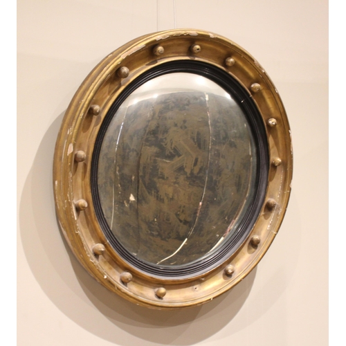 708 - A Regency giltwood and gesso circular convex wall mirror, the circular moulded frame applied with sp... 