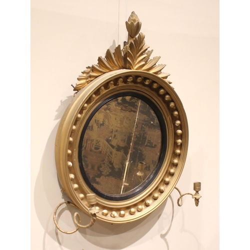 709 - A Regency girandole wall mirror, with a leafy fruit crest over the moulded circular frame applied wi... 