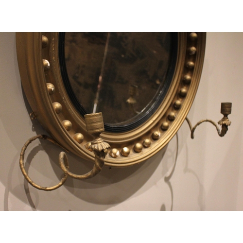 709 - A Regency girandole wall mirror, with a leafy fruit crest over the moulded circular frame applied wi... 