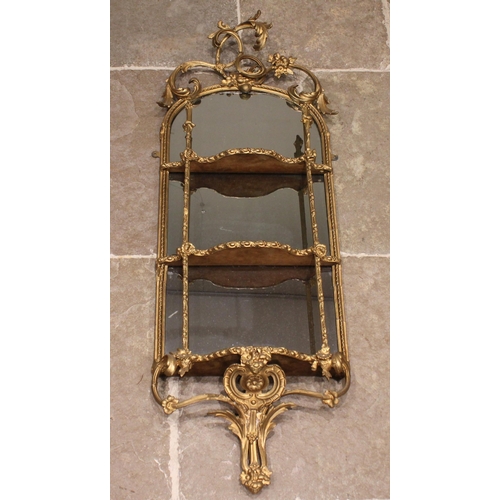 711 - A 19th century giltwood and gesso mirrored wall shelf, the openwork interlaced foliate crest over an... 