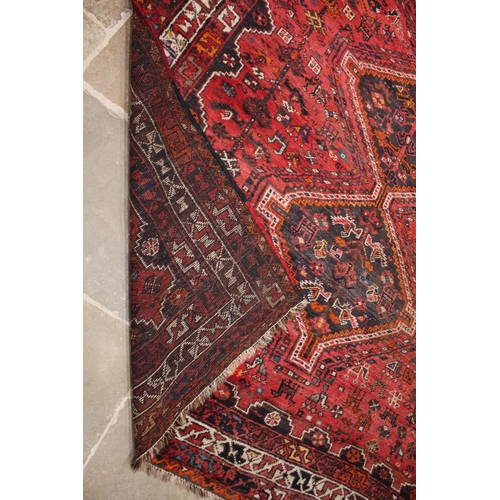 737 - An Iranian Shiraz rug, in red, brown, ivory and orange colourways, the all over foliate design punct... 