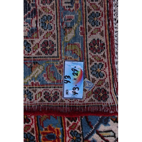 713 - A large red ground Persian Kashan carpet, in red, blue, green and ivory colourways, the central red ... 