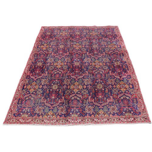 715 - A vintage blue ground Persian Tabriz carpet, with a traditional all over geometric design enclosed b... 