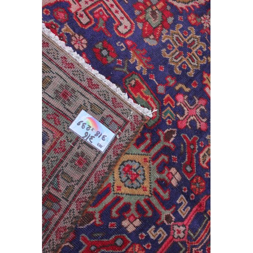 715 - A vintage blue ground Persian Tabriz carpet, with a traditional all over geometric design enclosed b... 