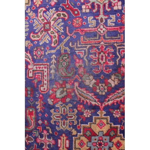 715 - A vintage blue ground Persian Tabriz carpet, with a traditional all over geometric design enclosed b... 