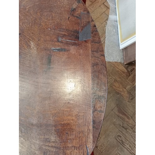 816 - A 19th century oak cricket table, the circular plank top upon three chamfered supports, united by a ... 