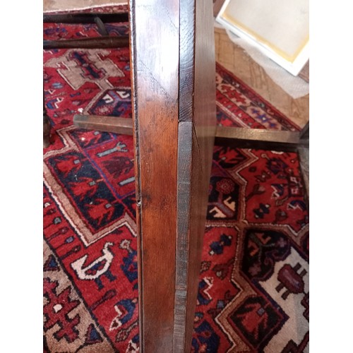 816 - A 19th century oak cricket table, the circular plank top upon three chamfered supports, united by a ... 