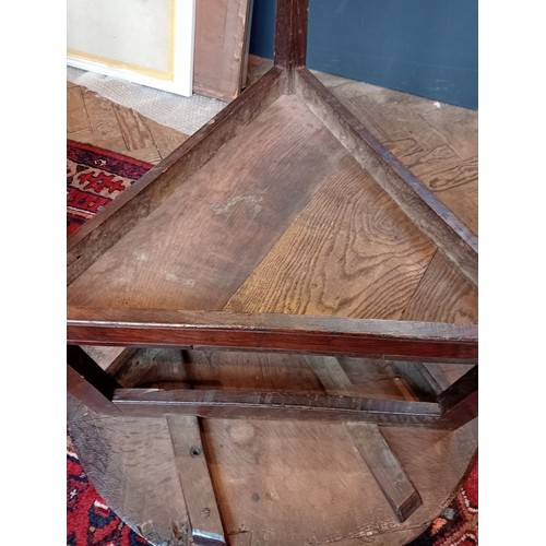 816 - A 19th century oak cricket table, the circular plank top upon three chamfered supports, united by a ... 