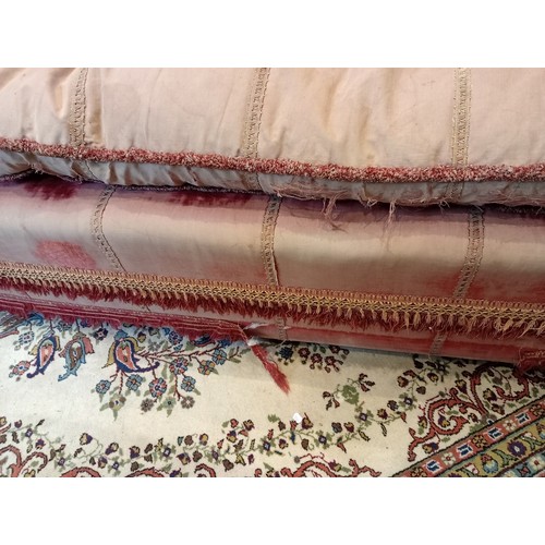 860 - An 18th century knoll or Knole sofa, in pink velour fabric applied with tassel fringes, the straight... 