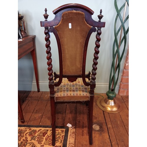 843 - A 19th century rosewood and upholstered elbow chair, the shield shaped padded back flanked by barley... 