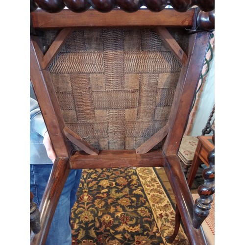 843 - A 19th century rosewood and upholstered elbow chair, the shield shaped padded back flanked by barley... 