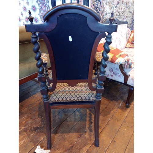 843 - A 19th century rosewood and upholstered elbow chair, the shield shaped padded back flanked by barley... 