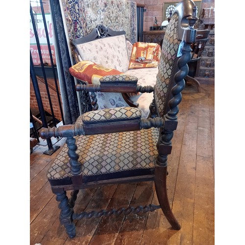 843 - A 19th century rosewood and upholstered elbow chair, the shield shaped padded back flanked by barley... 