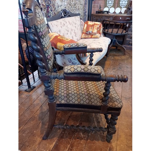 843 - A 19th century rosewood and upholstered elbow chair, the shield shaped padded back flanked by barley... 