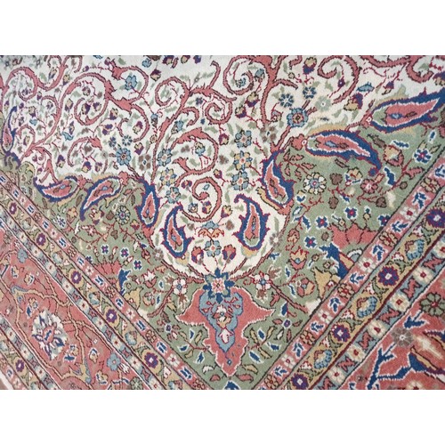 731 - A Kashan pattern carpet in ivory, green and salmon pink colourways, the central ogee medallion upon ... 