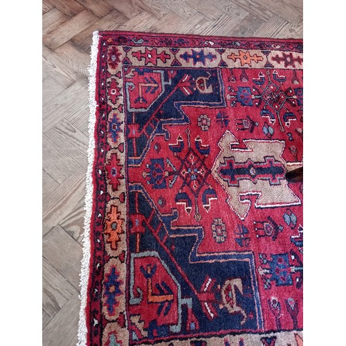 729 - A rich red ground Persian Heriz runner, bespoke medallion design, the three linked geometric medalli... 