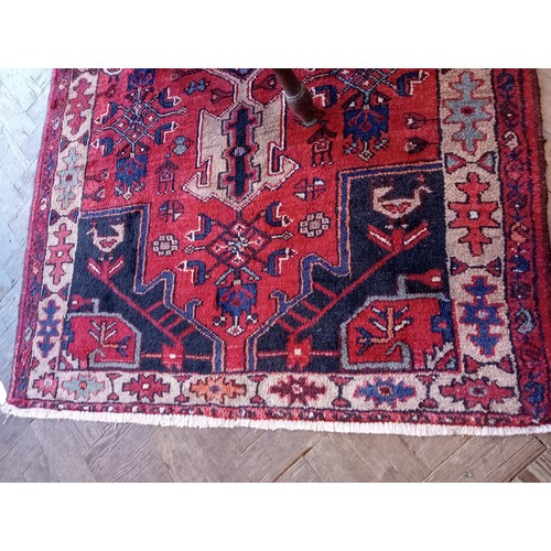 729 - A rich red ground Persian Heriz runner, bespoke medallion design, the three linked geometric medalli... 