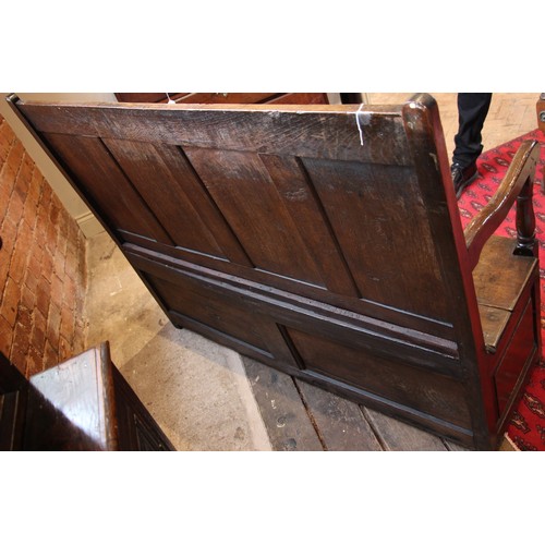 784 - An 18th century Welsh oak box settle, of cottage proportions, the four panel back extending to the d... 