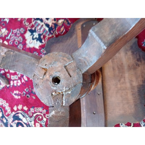 869 - A 19th century oak tripod table, the scalloped circular top upon a baluster column and three shaped ... 